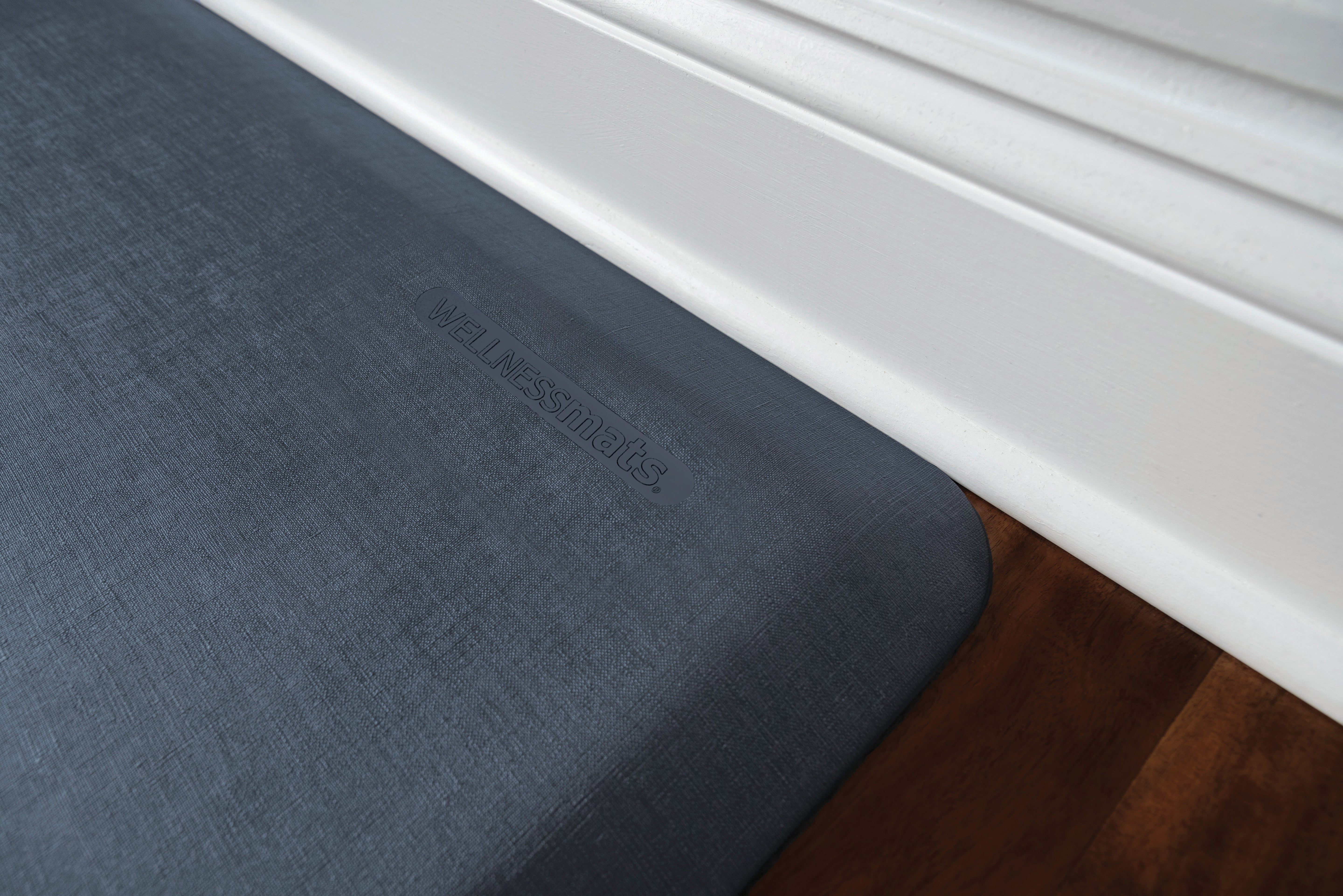 A up-close shot of 3'x2' Linen Lagoon WellnessMat on a wood floor.