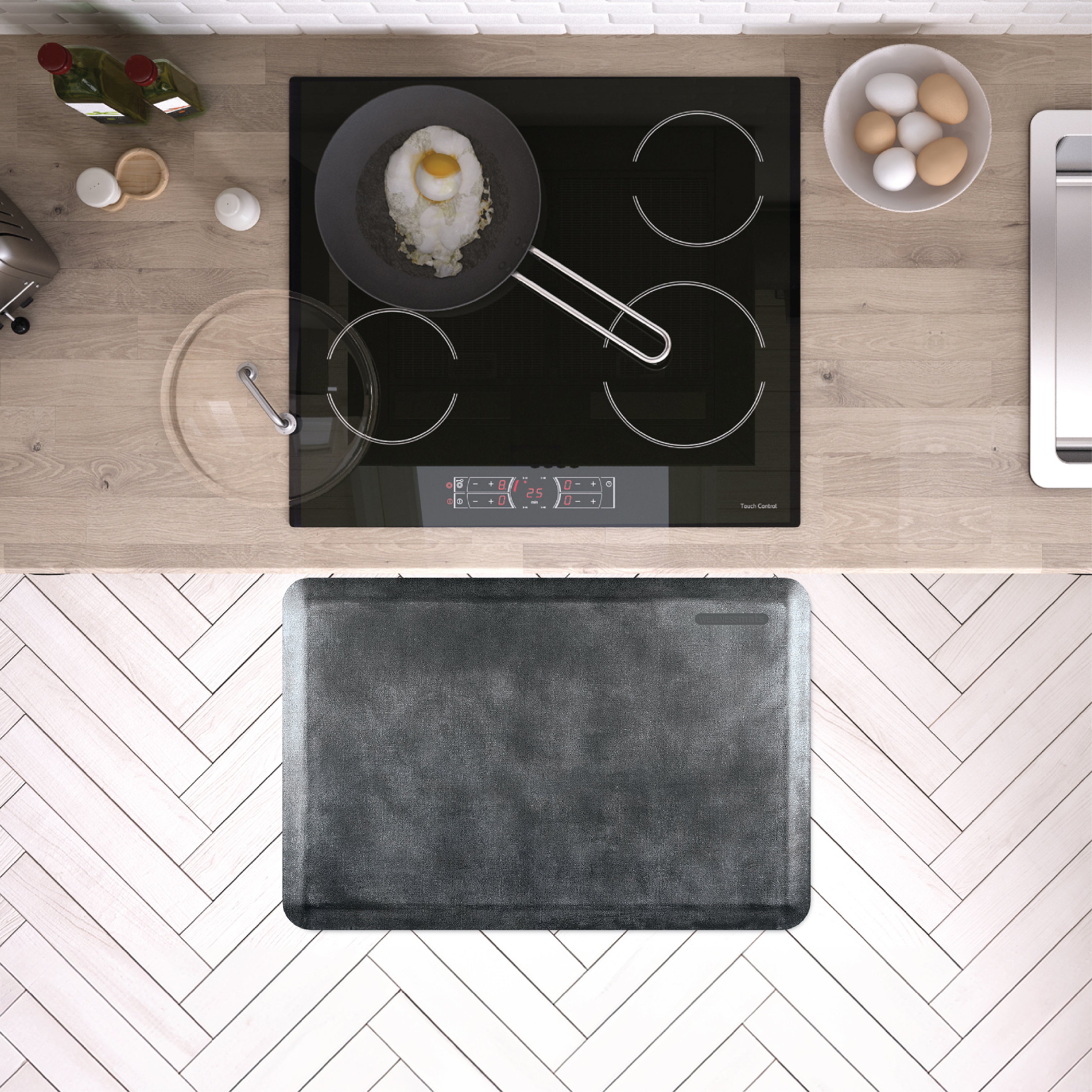 A 3'x2' Linen Onyx WellnessMat in front of a kichen stove.