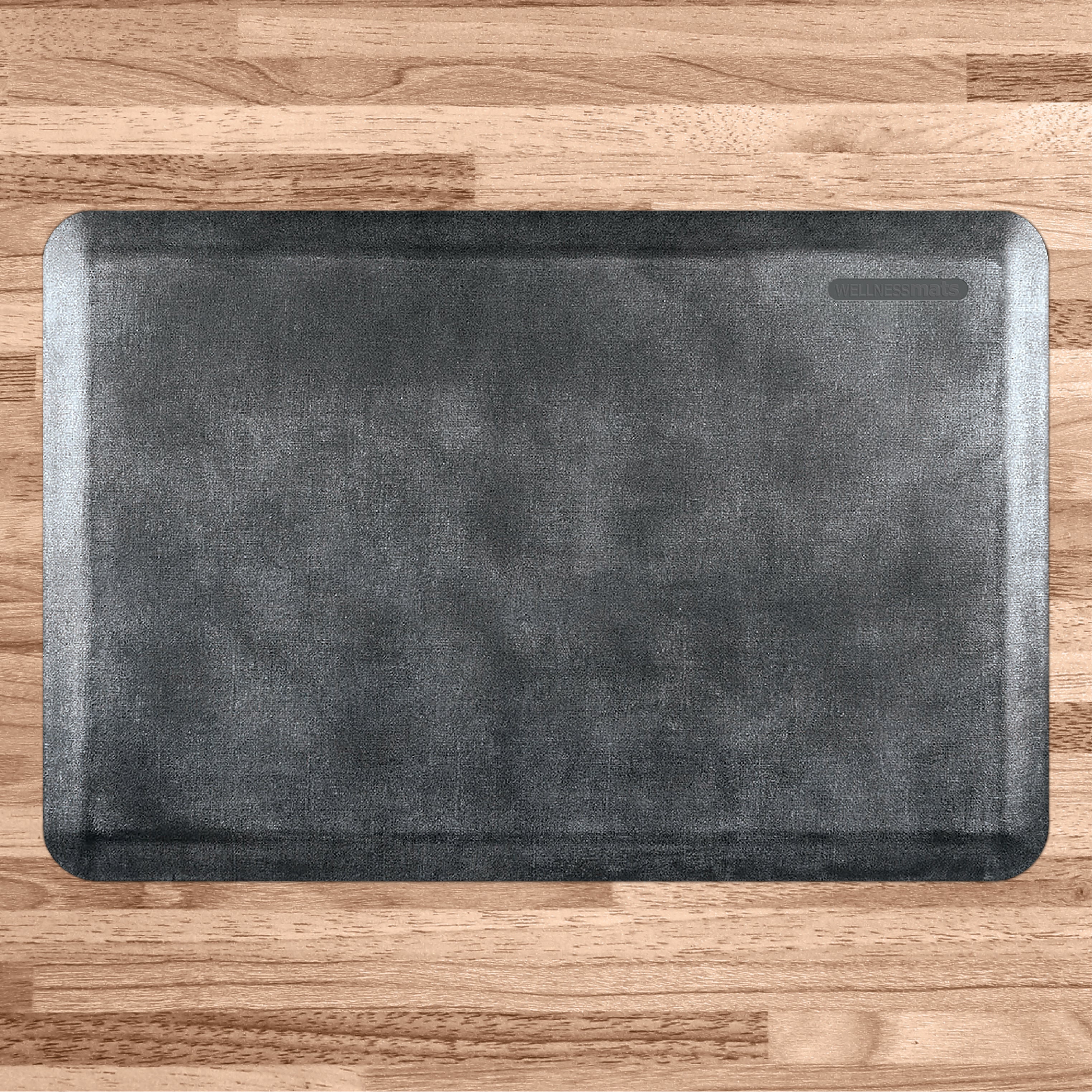 A 3'x2' Linen Onyx WellnessMat on a light wood floor.