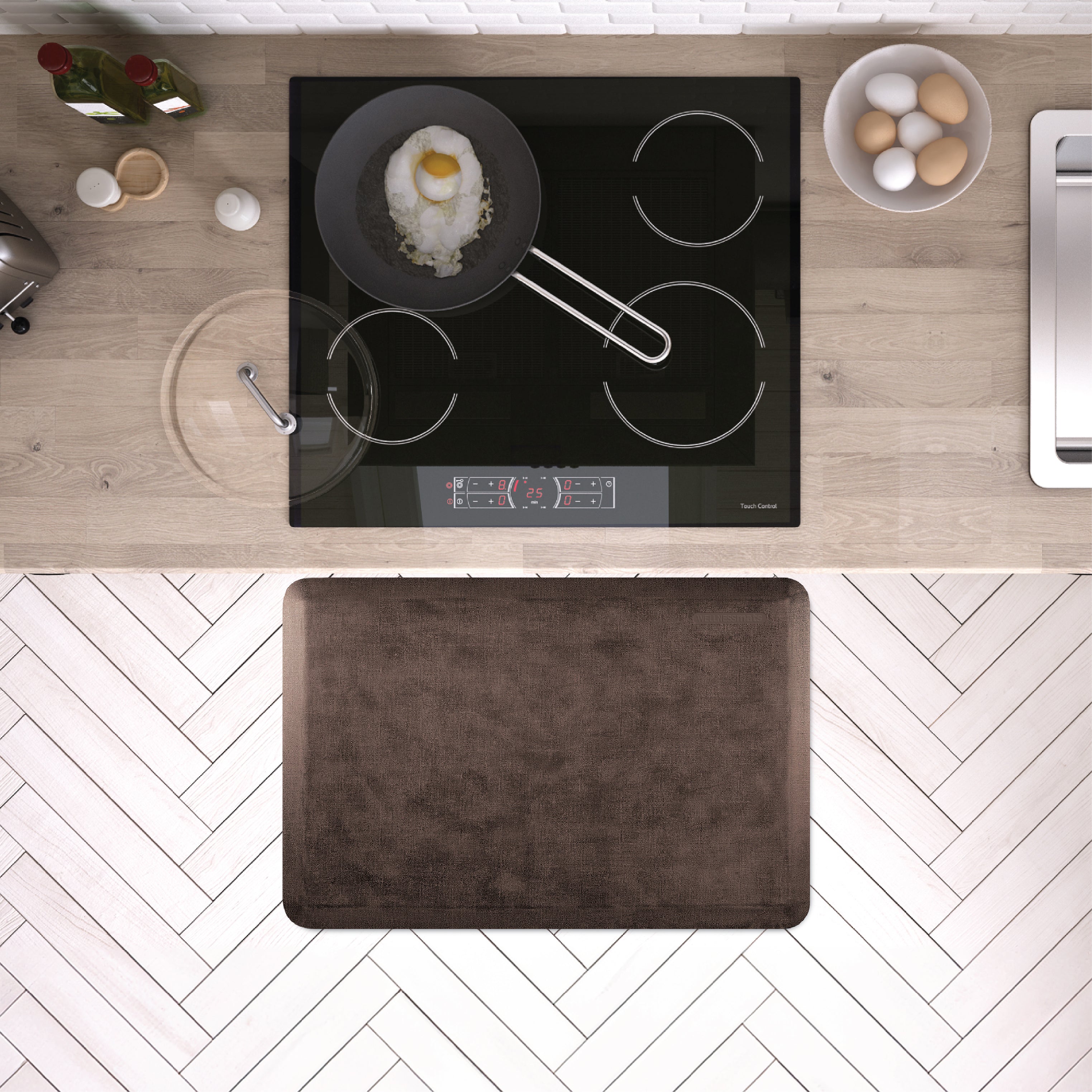 A 3'x2' Antique Dark WellnessMat in front of a kitchen stove.