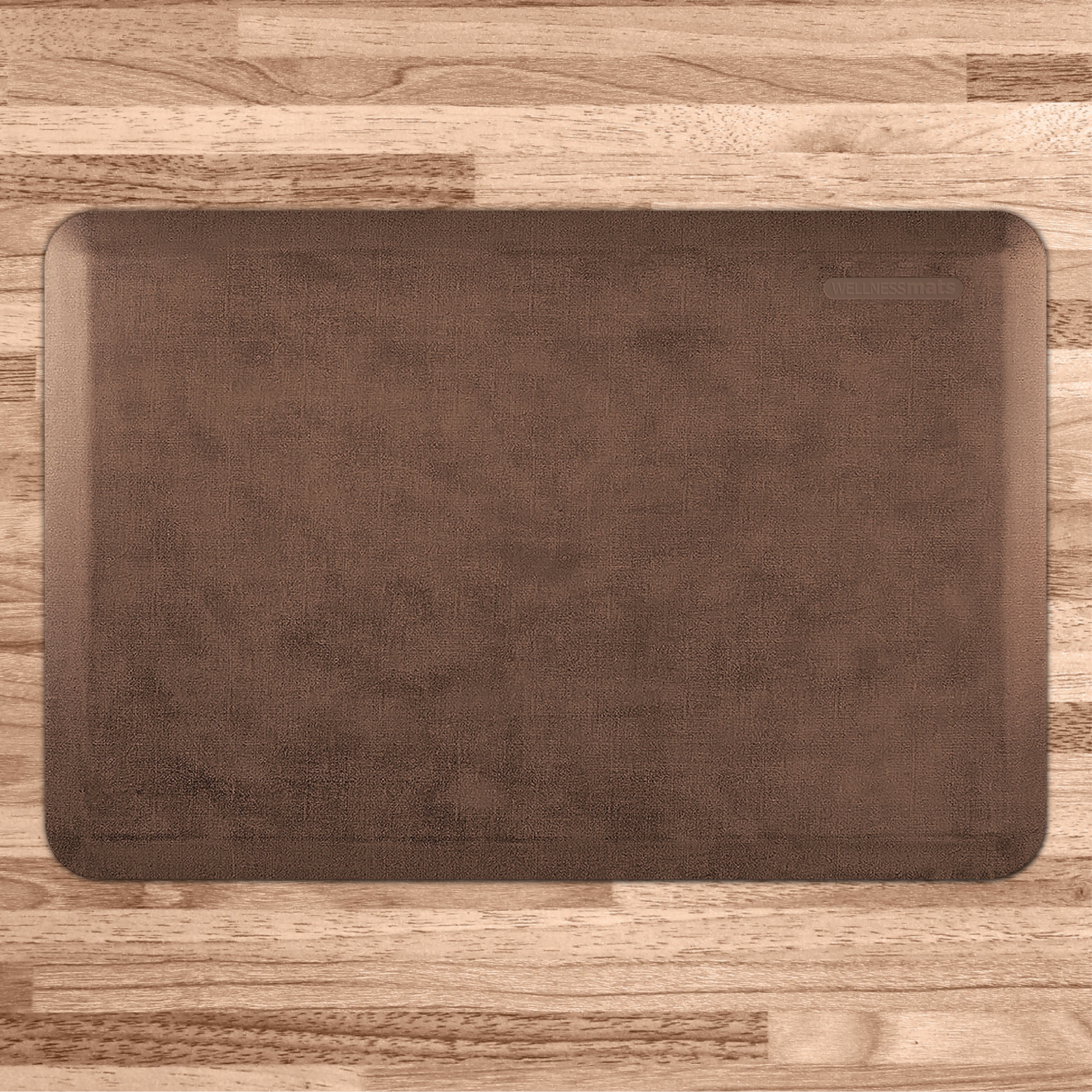 A 3'x2' Antique Light WellnessMat on a light wood floor.